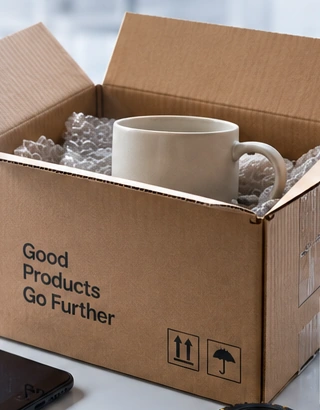 Illustrative ceramic mug sample in an opened protective shipping carton